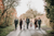 newlyweds and flower girl walking accompanied by groomsmen 