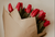 red tulip bouquet wrapped with brown paper 