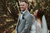 bride standing behind the groom in a forest 