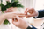 A groom puts a ring on bride's finger.