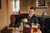 a smiling groom drinking whiskey in a chair