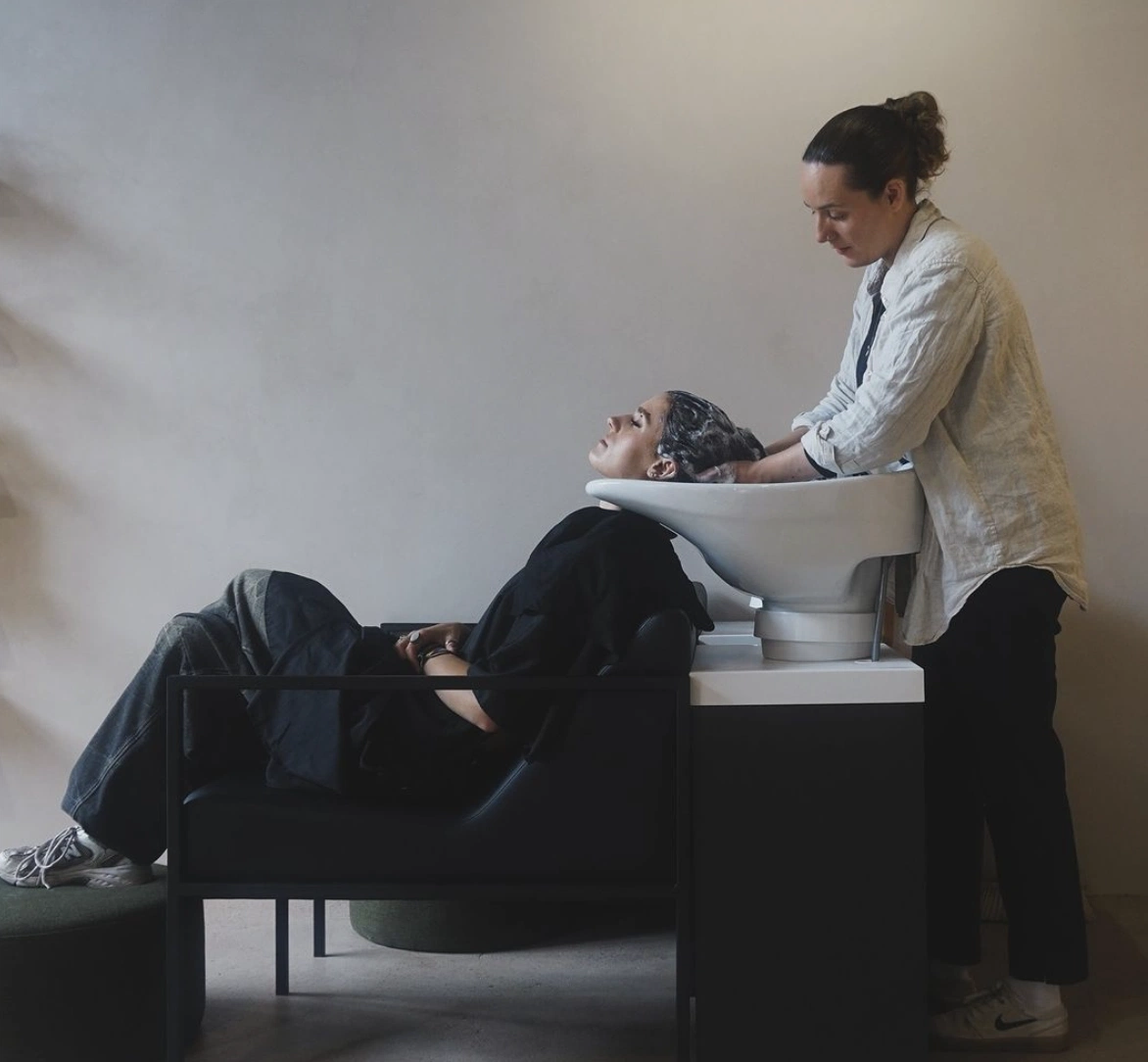 This image shows a person enjoying a relaxing hair wash experience at MOSU Hair Space