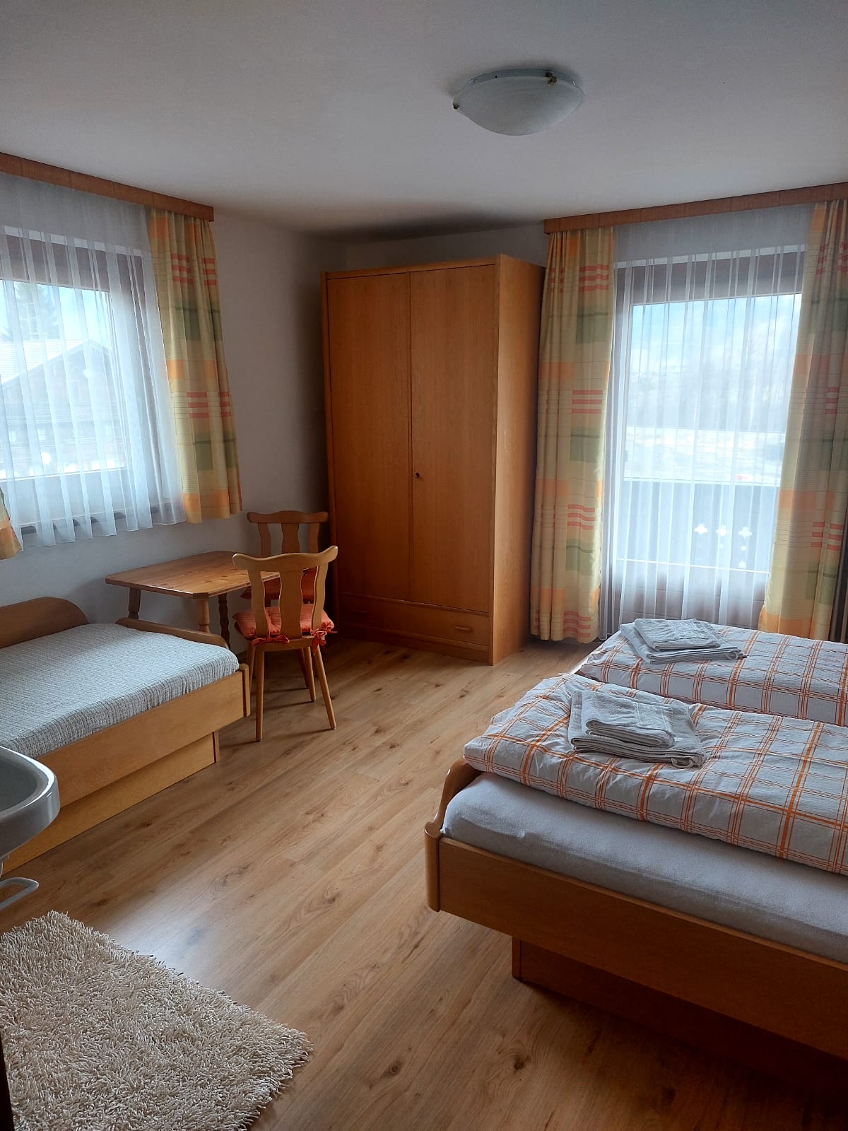 Room 2 with one double bed and one single bed with table and two chairs 