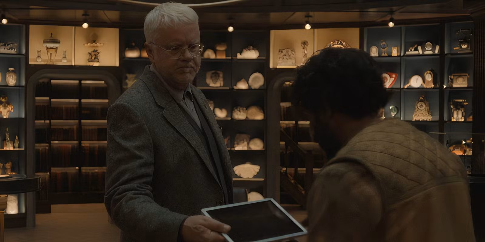 bernard-giving-lukas-a-tablet-computer-in-silo-season-2-s-episode-7.avif