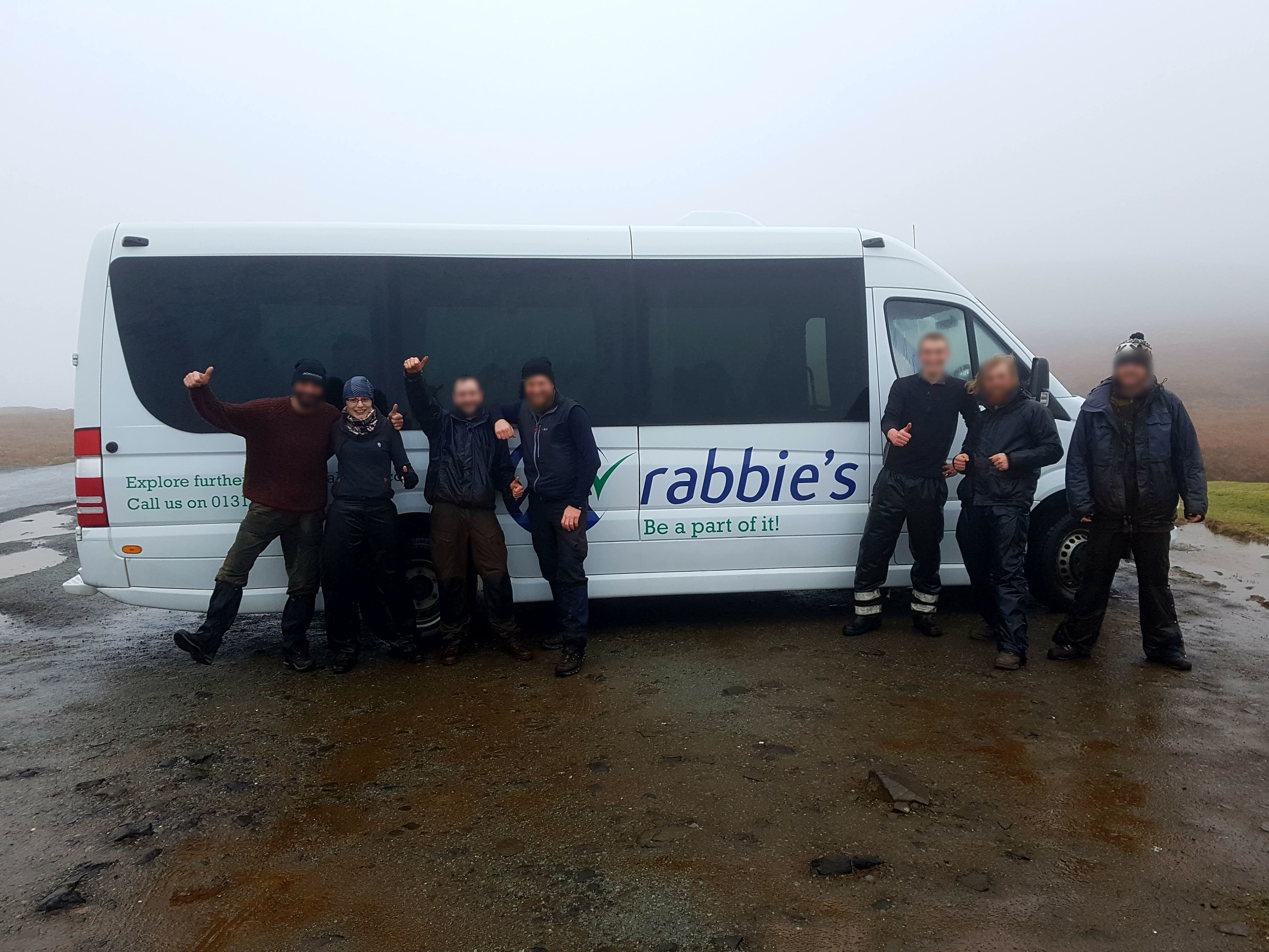 group of us happy next to rabbies bus