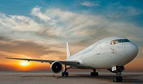 Avión bimotor de fuselaje estrecho en la pista de un aeropuerto al atardecer