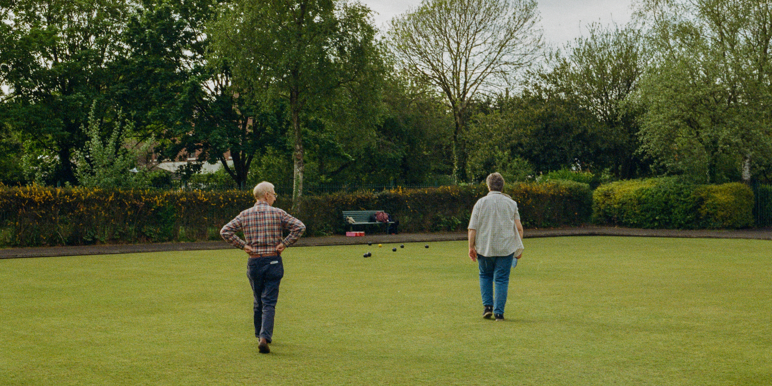 A crown green bowls game in progress with two players