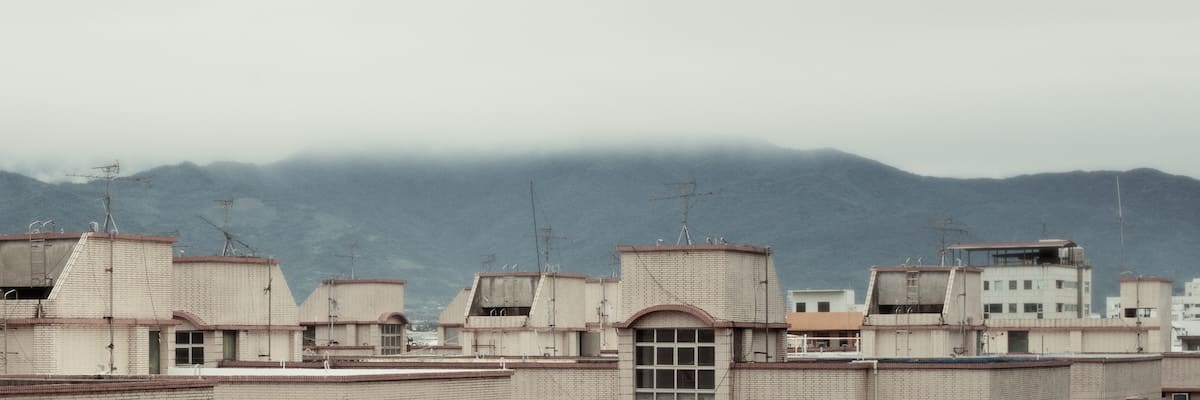 cityscape against a mountain range covered in clouds