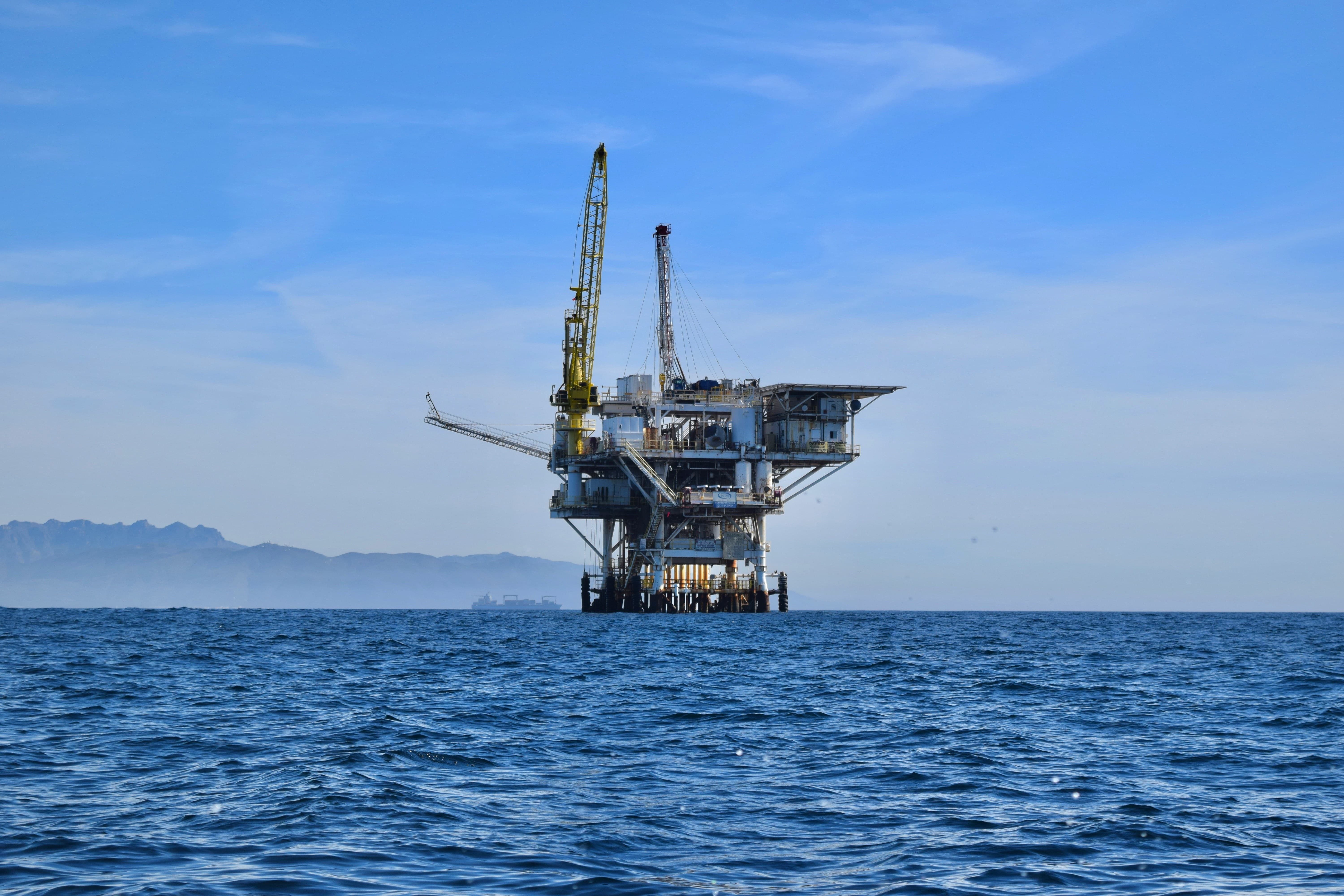 An image of an oil rig out at sea on a clear day.