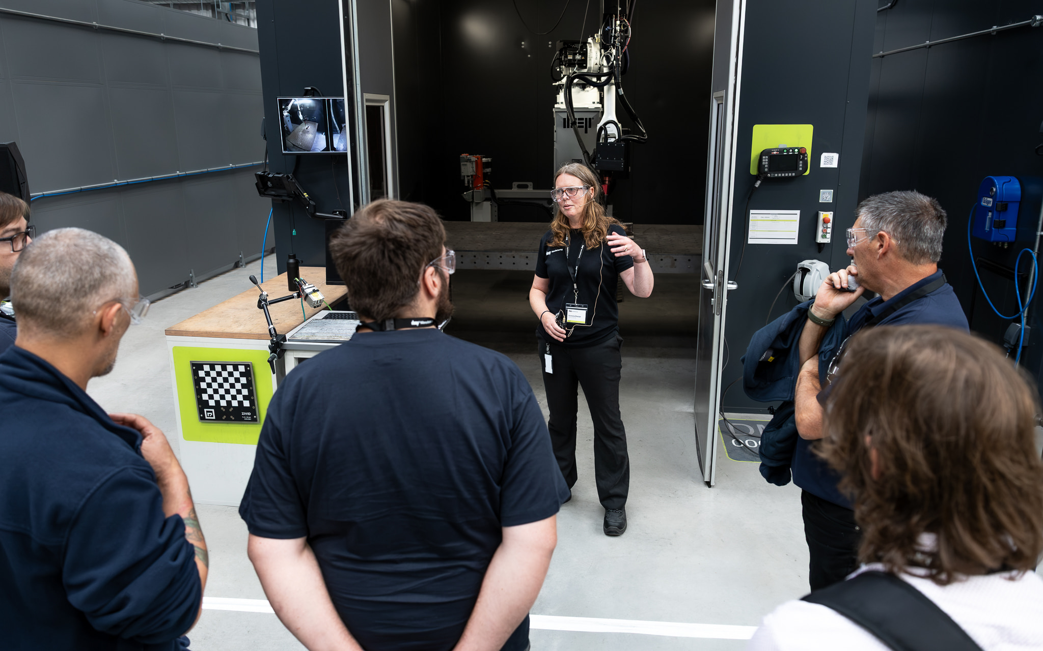 Person stood in front of WAAM robot talking to crowd