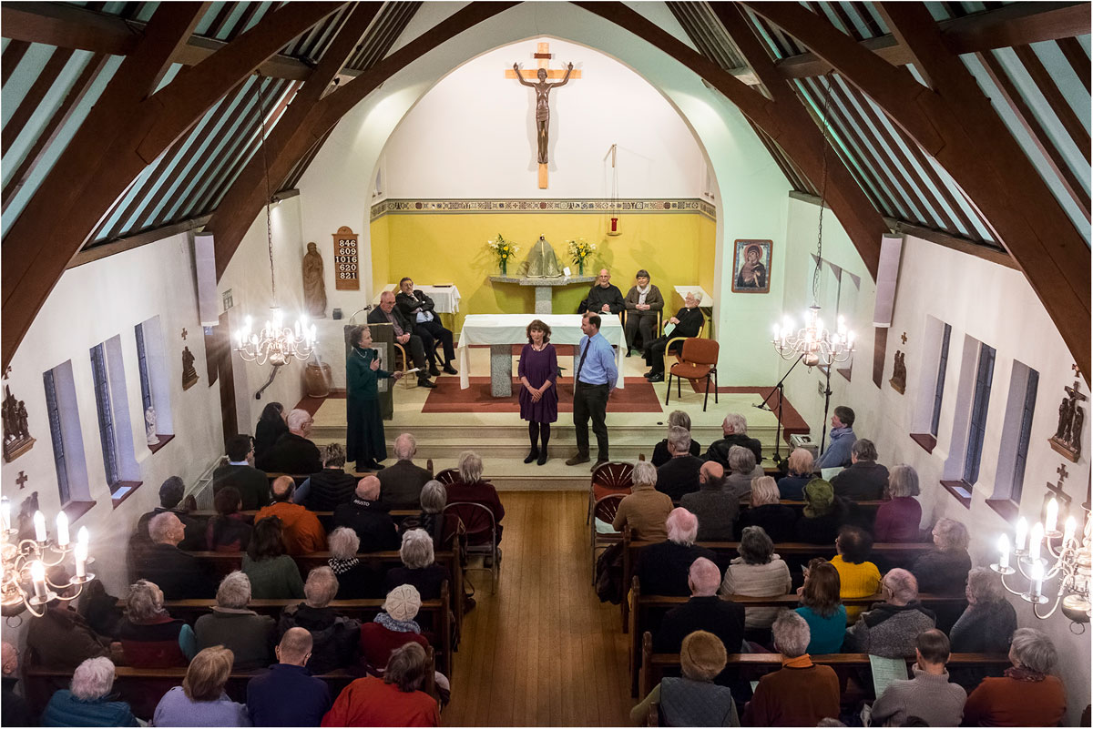 Inside Holy Cross church, seen from the back, with the pews full for a recital