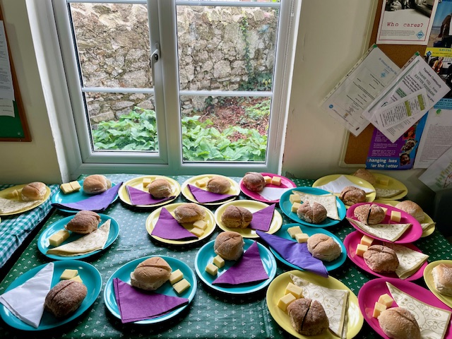 Plates laid with bread rolls and cheese in the church meeting room for a Lent Lunch